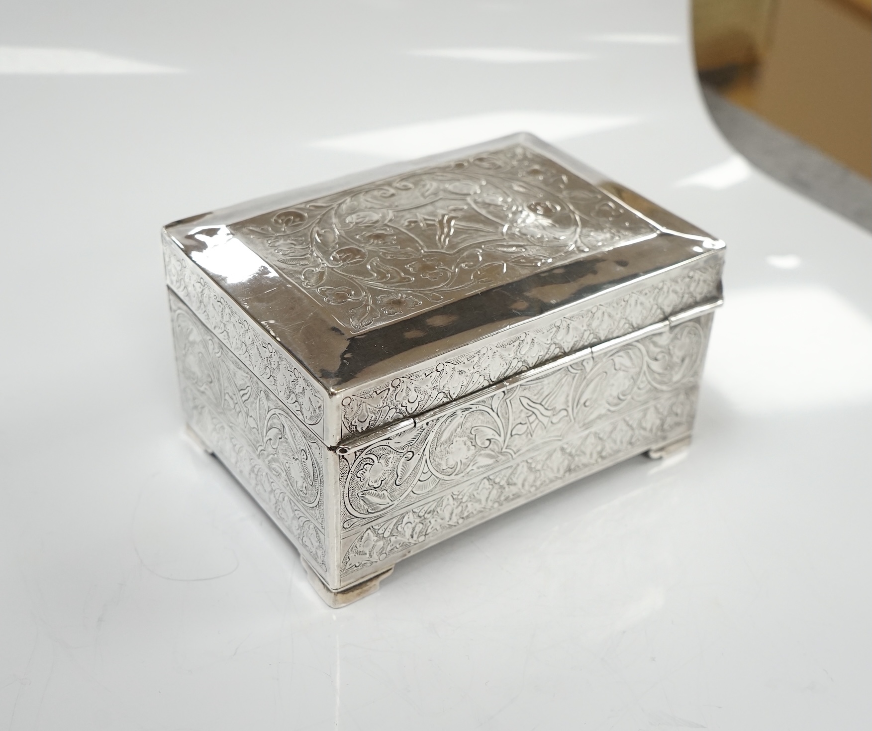 Two silver cigarette cases, a silver plated cigarette case and a Thai? white metal cigarette box, 11.6cm. Condition - poor to fair